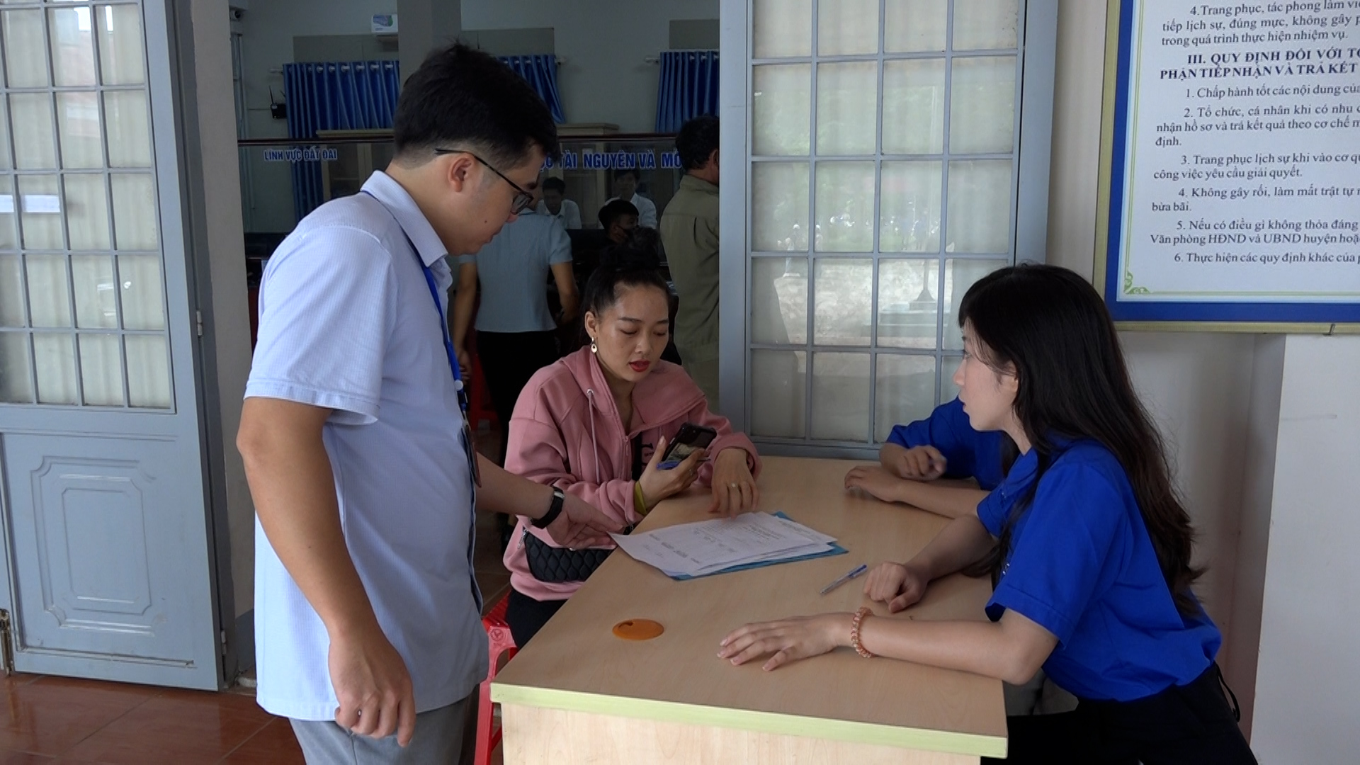 đoàn thanh niên và cán bộ trung tâm hành chính công xã hỗ trợ người dân làm thủ tục đăng ký giấy khai sinh